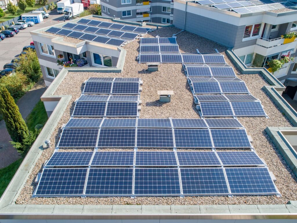 dienstleistungen-photovoltaikanlage-dachflaeche-erneuerbare-energie-dach-kies-balkon-grünpflanzen-parkplatz-solar